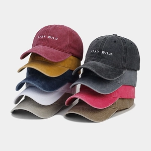 Dettaglio di cappellini da baseball vintage in cotone lavato con ricamo Stay Wild in vari colori