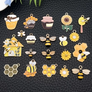 Macro shot of 20 mixed bee and honeycomb themed enamel pendants for DIY jewelry