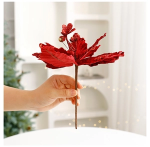 Detail of red velvet poinsettia with glitter petals held by hand for Christmas decor