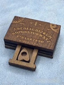 Detailed engraving on miniature wooden ouija board box with sliding drawer and heart pointer