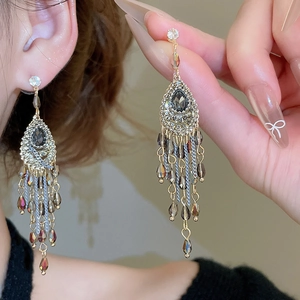 Macro shot of silver drop earrings featuring crystal tassels and sparkling rhinestones