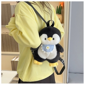 Rear view of a cute penguin plush backpack with a blue plaid daisy bib worn by a model