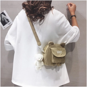 Khaki canvas crossbody bag with bear ears, plush charm and fashion text patch detail