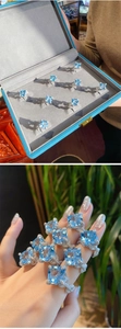 Detailed view of square blue gemstone ring with crisscross pave diamond band