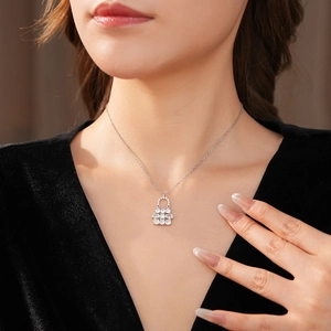 Donna elegante che indossa una collana con ciondolo a borsa in argento e zirconi sul collo