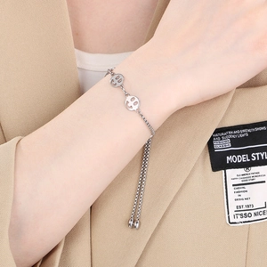 Dettaglio di un bracciale regolabile in acciaio inossidabile con ciondoli smiley