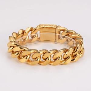 Chunky gold stainless steel Cuban link bracelet with a skull clasp for men on white background