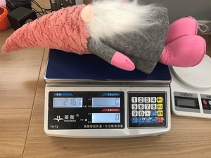 Detail showing the exact weight of the pink Christmas gnome on a digital scale