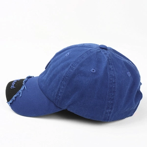 Detailed macro shot of distressed baseball cap brim featuring blue letter embroidery