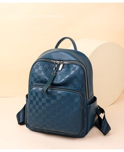 Detail of navy blue PU leather backpack with embossed checkerboard pattern and silver zipper
