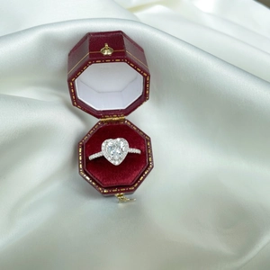 Close-up of heart-shaped silver ring with zircon in a red velvet vintage jewelry box