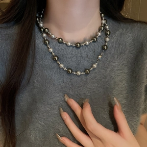 Gros plan d'un collier de perles double épaisseur argent et gris sur un mannequin