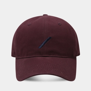 Close-up of wine red twill cotton baseball cap featuring minimalist blue stripe embroidery