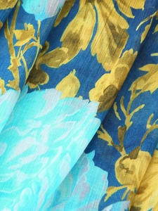 Close-up of blue floral chiffon fabric with yellow leaf pattern and light blue flowers