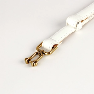 Close-up of white leather belt strap with refined stitching and golden metal buckle