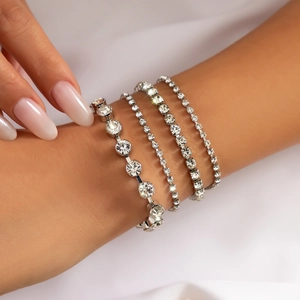 Close-up of sparkling silver rhinestone bracelet set stacked on a wrist with silk background