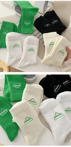 Detailed embroidery of dreamer text and triangle icons on ribbed cotton crew socks