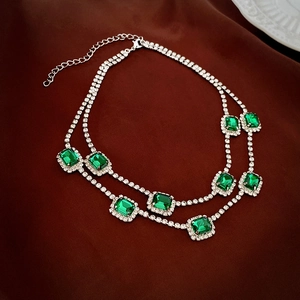 Detail of vintage emerald style double layered silver necklace with square crystals