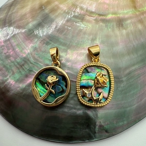 Macro detail of 18K gold-plated rose pendants with colorful abalone shell inlay