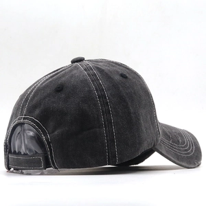 Detail view of charcoal gray washed baseball cap with white contrast stitching and distressed holes