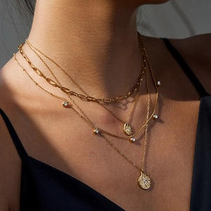 Layered gold stainless steel star pendant necklace with crystal accents worn by model
