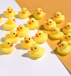 Group of mini yellow rubber ducks for bath time fun arranged on a dual-tone background