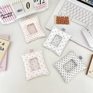 Detail of plush cotton padded card holders in star and polka dot patterns on a desk