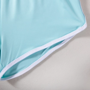Detailed close-up of light blue sports shorts with white trim and reinforced stitching