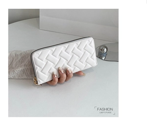 Close-up of white quilted PU leather long wallet held by hand with gold metal zipper