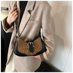Détail du sac léopard avec bordure en cuir noir et boucle carrée argentée sur le devant