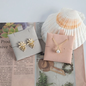 Close-up of velvet jewelry display pads with pearl necklace and petal stud earrings