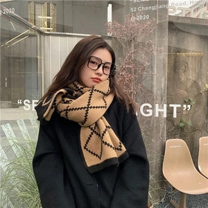 Detail of warm knit scarf featuring a classic brown and black checkered rhombus pattern