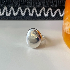 Macro shot of minimalist 925 sterling silver ring with irregular oval polished surface