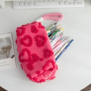 Detail of pink fleece pencil case with heart embossing and spacious interior for pens