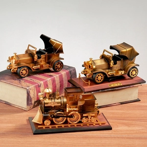 Close-up of vintage bronze steam train and antique car models on display stands