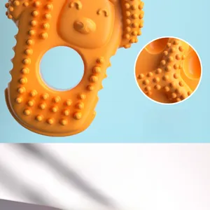Detail showing orange dog chew toy with textured cleaning bumps and durable rubber material