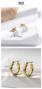 Detailed view of gold plated earrings with white enamel spiral texture on stone base