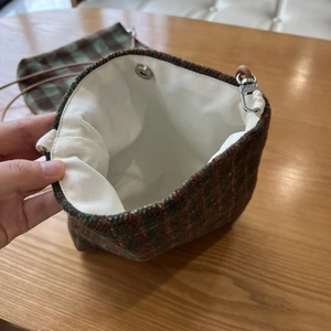 Detail view of the vintage plaid wool crossbody bag with canvas lining and magnetic buckle