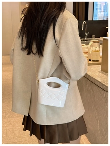 Dettaglio della mini borsa a secchiello bianca in PVC con motivo trapuntato e catena