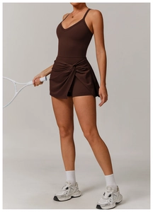 Detail of chocolate brown tennis dress featuring v-neck top and knotted pleated skirt
