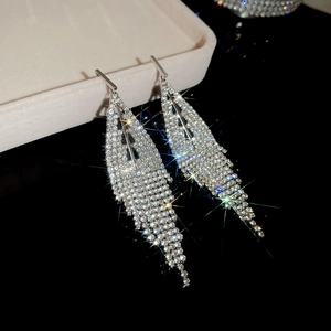 Detailed close-up of sparkling triangle fringe earrings with silver tassels and zircons