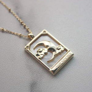 Detail of a vintage gold-plated necklace featuring a mother-of-pearl Moon pendant and beads