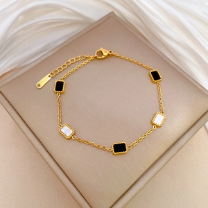 Detailed macro shot of gold titanium steel bracelet with black and white enamel cubes