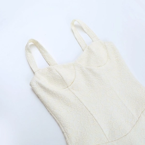 Détail du caraco en dentelle crème montrant les motifs floraux et la structure des bonnets