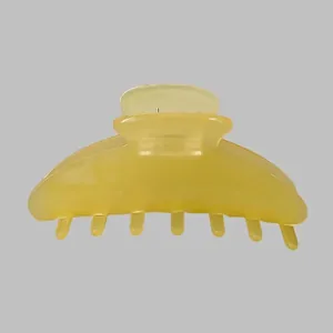 Close-up of a large yellow acetate hair claw clip with a glossy translucent finish