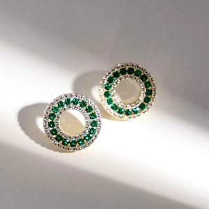 Elegant gold circular earrings featuring emerald green and white zirconia pavé stones