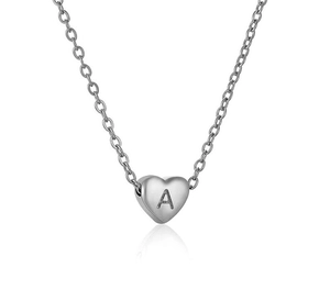 Detailed macro shot of a heart-shaped pendant with an engraved letter A on a silver chain