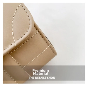 Macro detail of fine stitching and beige quilted leather on a mini square chain bag