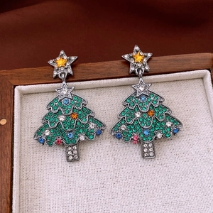 Detailed view of Christmas tree earrings with colorful crystals on a vintage fabric base