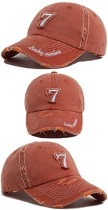 Detail of distressed baseball cap featuring white number 7 embroidery and lucky number text